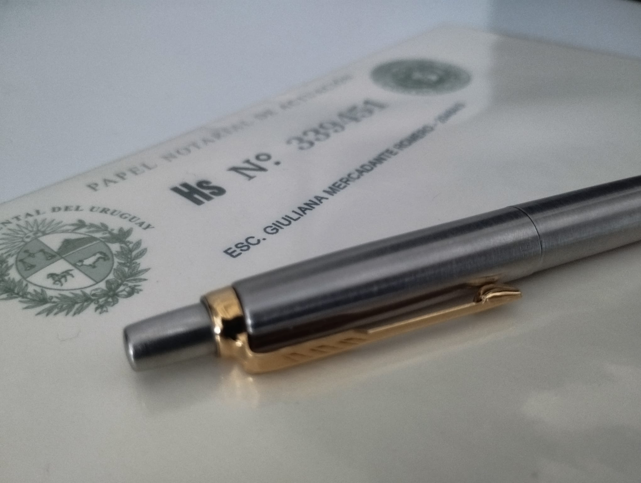 Plano cercano de una lapicera sobre un documento notarial firmado por Giuliana Mercadante.